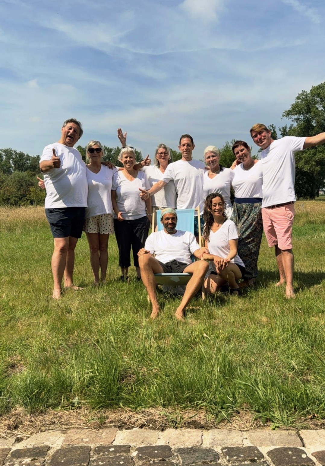 Groupe de participants tout en blanc dans la prairie d'Ichtegem, retraite d'été juin 2026
