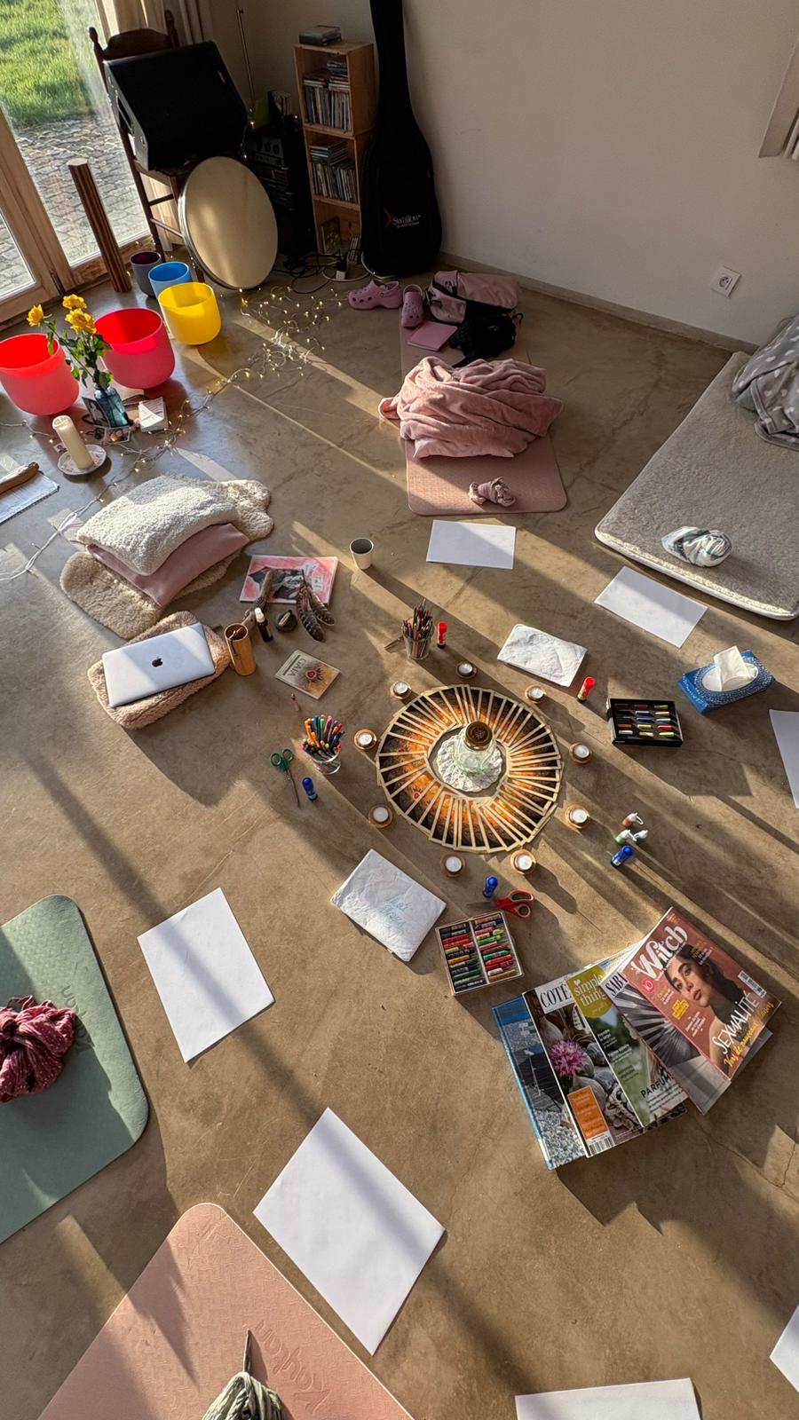 Salle de pratique avec mandala de bougies au sol, tapis et bols de cristal, retraite d'été 2026