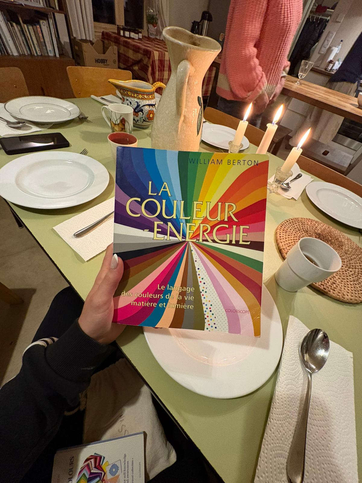 Livre La Couleur-Énergie de William Berton à table à la lueur des bougies, retraite d'été 2026